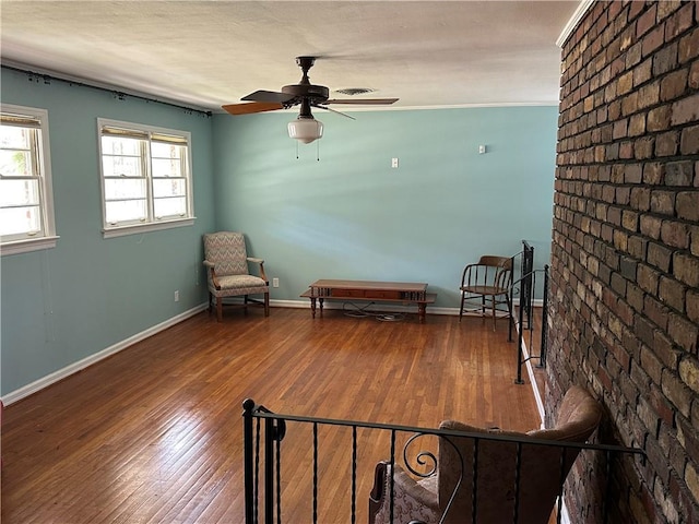 unfurnished room with wood finished floors, a ceiling fan, and baseboards