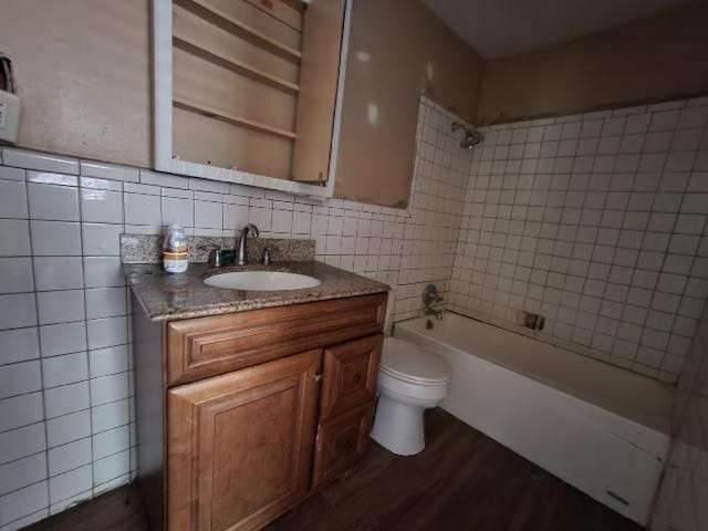 2805 Banks Ave, Mobile, AL 36617 - bathroom with tile walls, washtub / shower combination, vanity, wood finished floors, and decorative backsplash