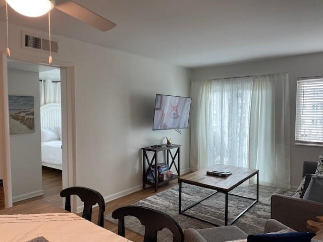 living room with wood-type flooring and ceiling fan