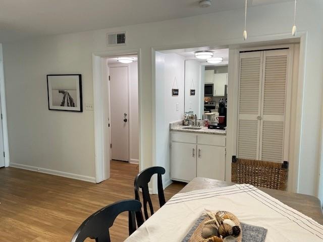 dining space featuring light wood-type flooring and sink