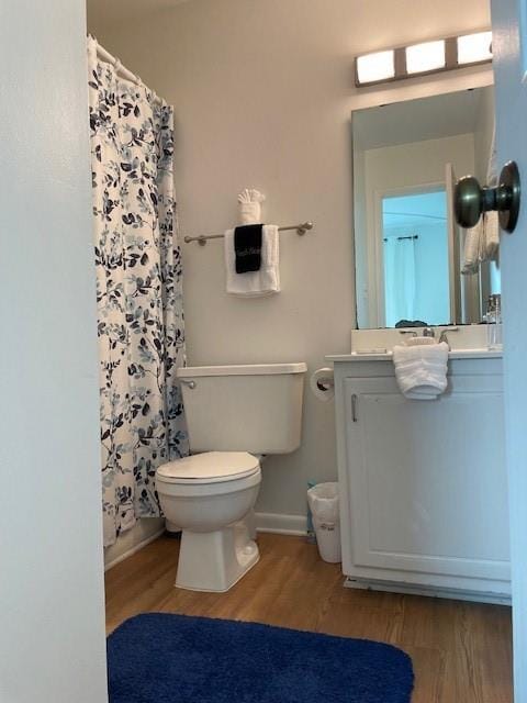 bathroom with vanity, toilet, and hardwood / wood-style flooring