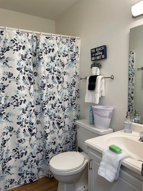 bathroom with curtained shower, toilet, hardwood / wood-style flooring, and vanity