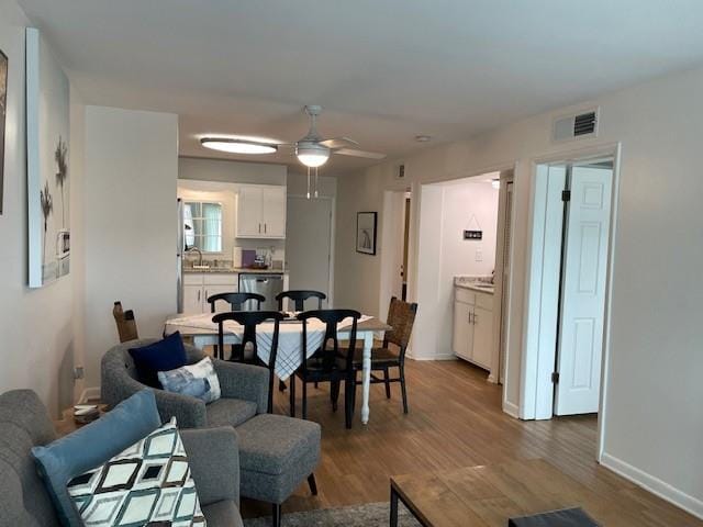 dining space with ceiling fan and hardwood / wood-style floors