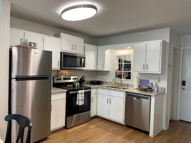 kitchen featuring light hardwood / wood-style flooring, sink, appliances with stainless steel finishes, and white cabinetry