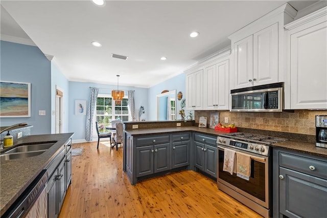kitchen with crown molding, appliances with stainless steel finishes, a sink, gray cabinets, and white cabinetry