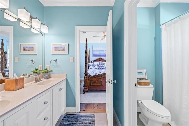 ensuite bathroom featuring a sink, toilet, double vanity, and connected bathroom