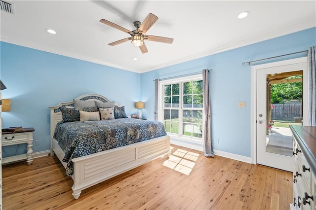bedroom with access to outside, multiple windows, and light wood-style floors