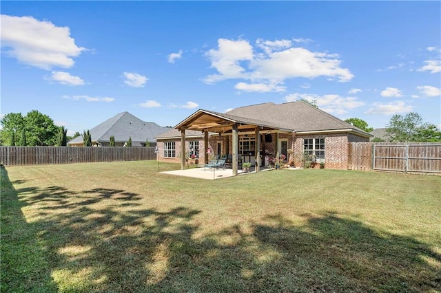 back of property with brick siding, a fenced backyard, a patio area, and a yard