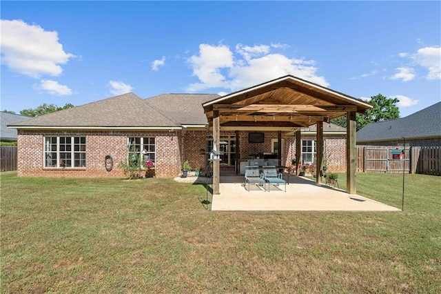 back of property with a lawn, a fenced backyard, a patio area, and brick siding