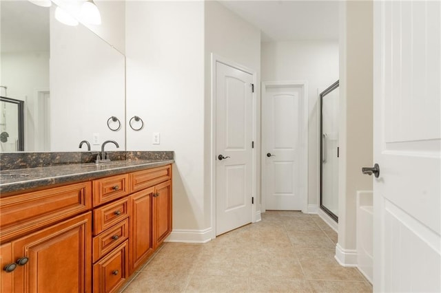 bathroom featuring tile patterned flooring, a shower stall, vanity, and baseboards