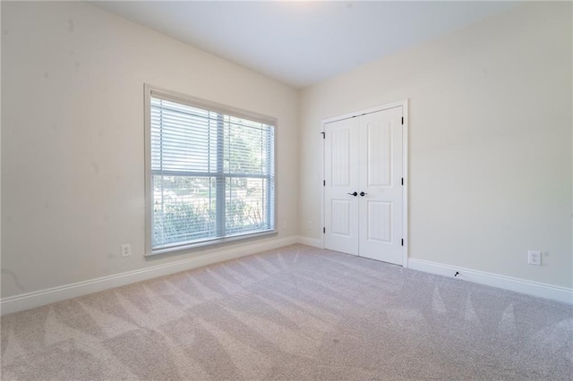 unfurnished room with carpet and baseboards