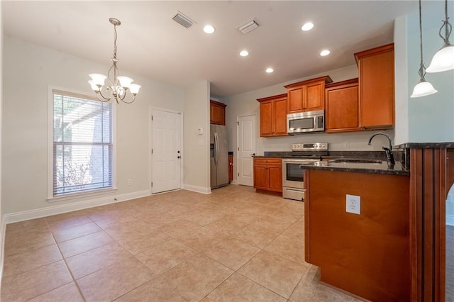 kitchen with visible vents, appliances with stainless steel finishes, brown cabinets, and a sink