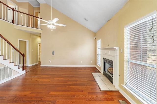 unfurnished living room featuring a fireplace, stairway, ceiling fan, wood finished floors, and baseboards