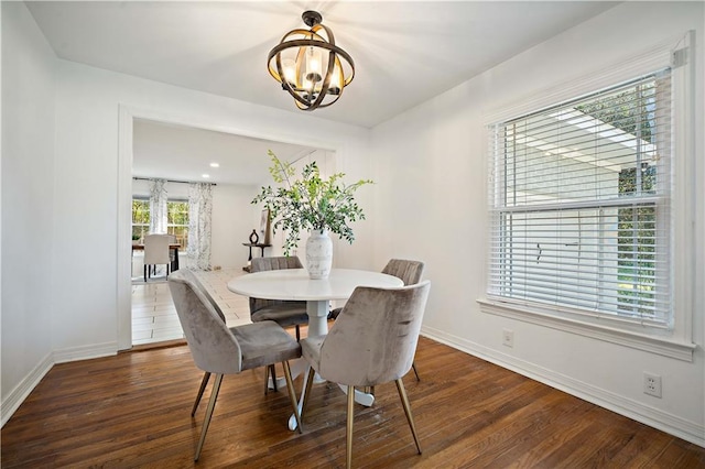 dining space with baseboards, a chandelier, and wood finished floors