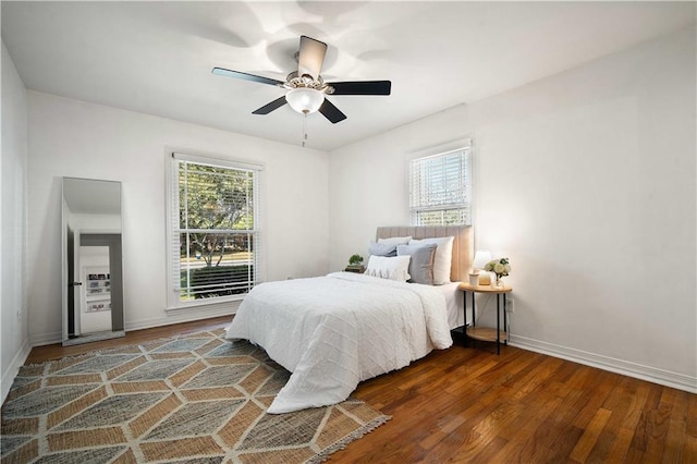 bedroom with ceiling fan, baseboards, and wood finished floors