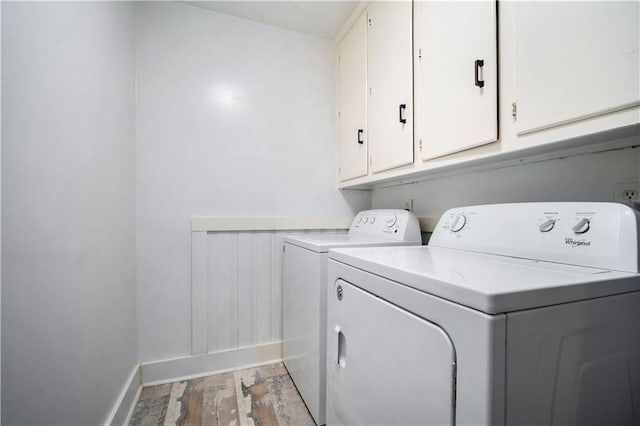 laundry area featuring light wood-style floors, washer and dryer, cabinet space, and baseboards