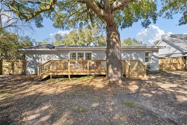 back of property featuring fence and a deck