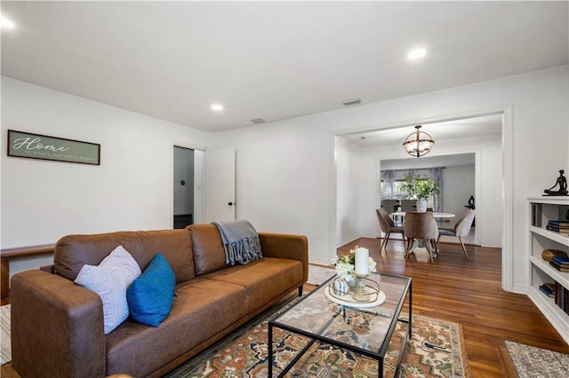 living area featuring a chandelier, recessed lighting, wood finished floors, visible vents, and baseboards