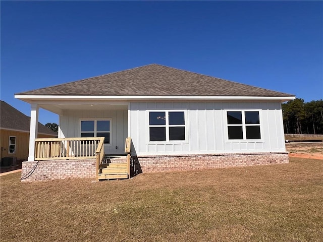 rear view of property featuring a yard