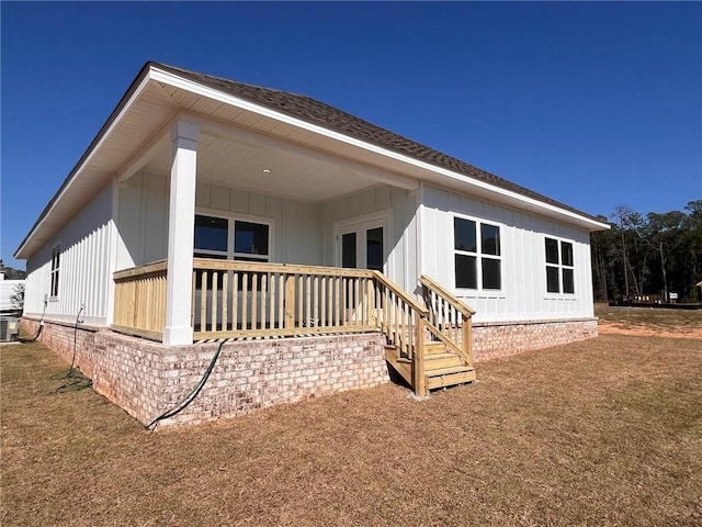 back of property with central air condition unit and a lawn