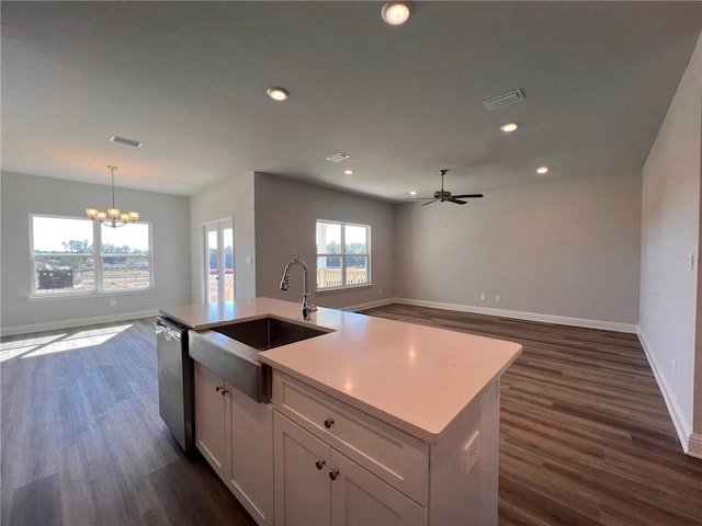 kitchen featuring dishwasher, an island with sink, sink, white cabinetry, and decorative light fixtures