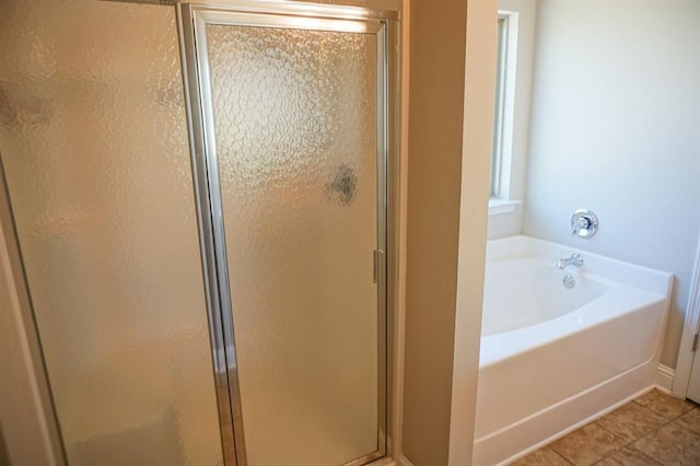 bathroom with a stall shower, tile patterned flooring, and a bath