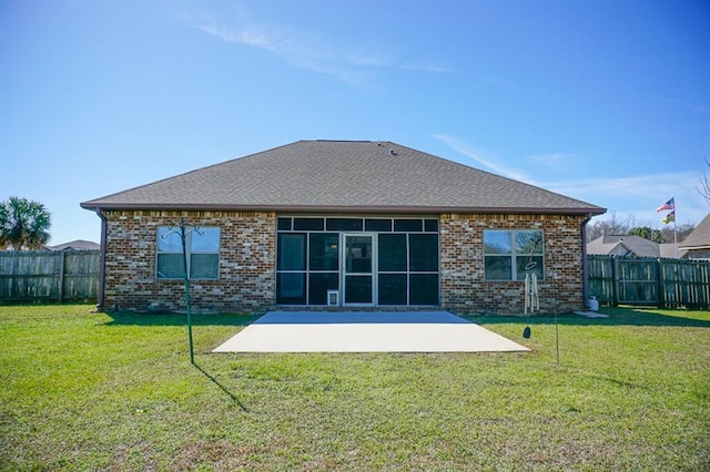 rear view of property with brick siding, a fenced backyard, a yard, and a patio