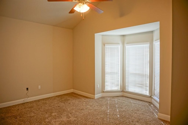 spare room with carpet, vaulted ceiling, baseboards, and ceiling fan