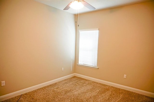 carpeted empty room with ceiling fan and baseboards