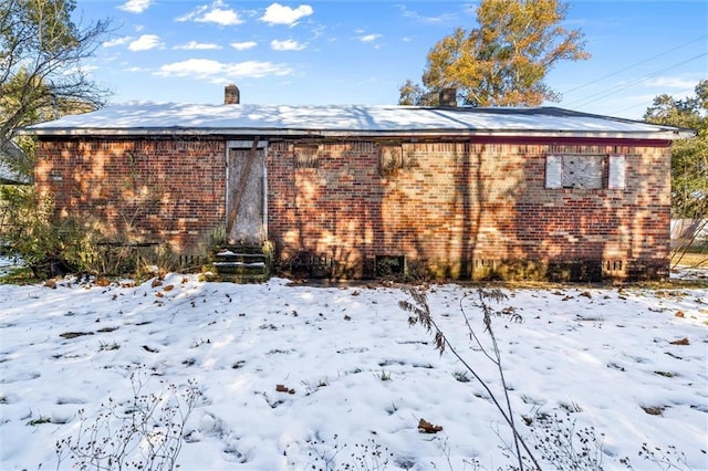 view of snow covered back of property