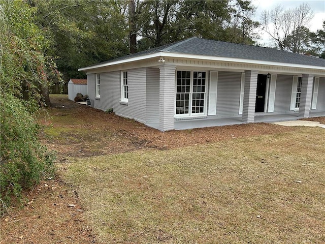 view of home's exterior with covered porch, a patio area, and a yard