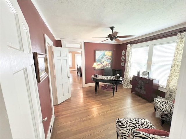 interior space featuring crown molding, a textured ceiling, hardwood / wood-style flooring, and ceiling fan