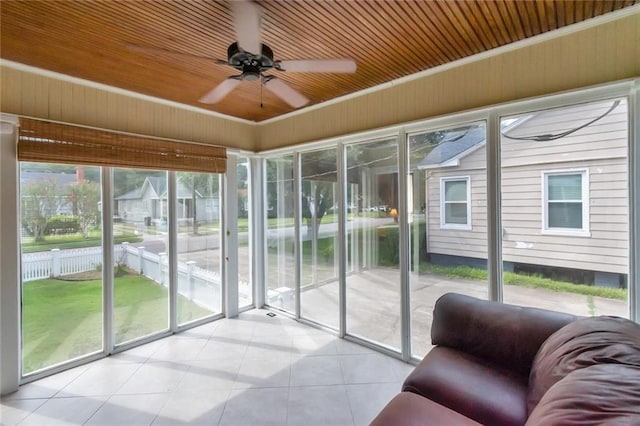 unfurnished sunroom featuring wood ceiling, a healthy amount of sunlight, and ceiling fan