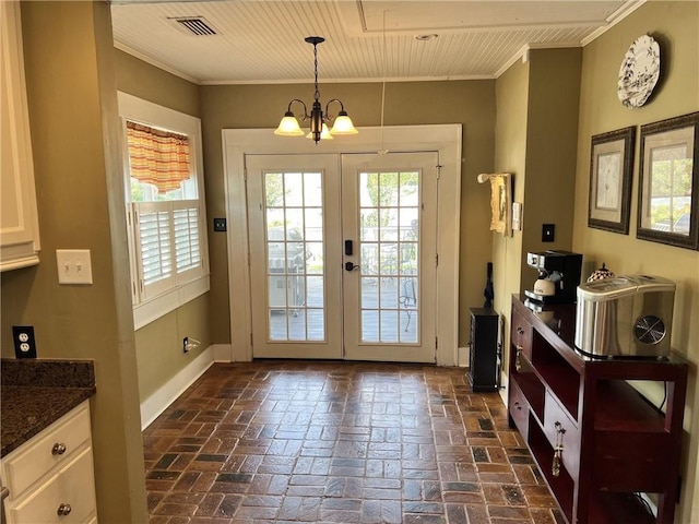 entryway featuring ornamental molding, a notable chandelier, and a healthy amount of sunlight