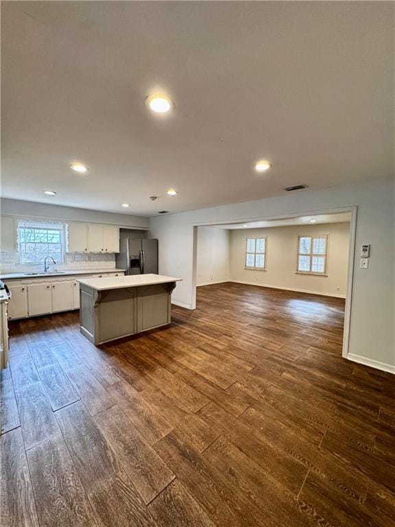 kitchen featuring dark hardwood / wood-style flooring, sink, a center island, and stainless steel refrigerator with ice dispenser