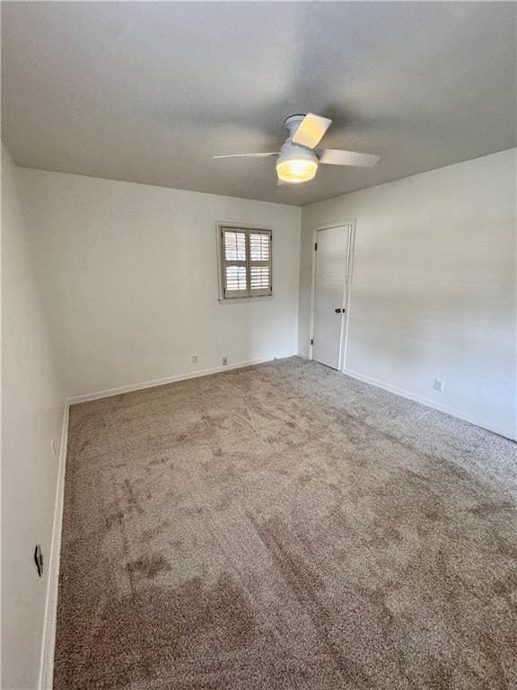 spare room featuring ceiling fan and carpet floors