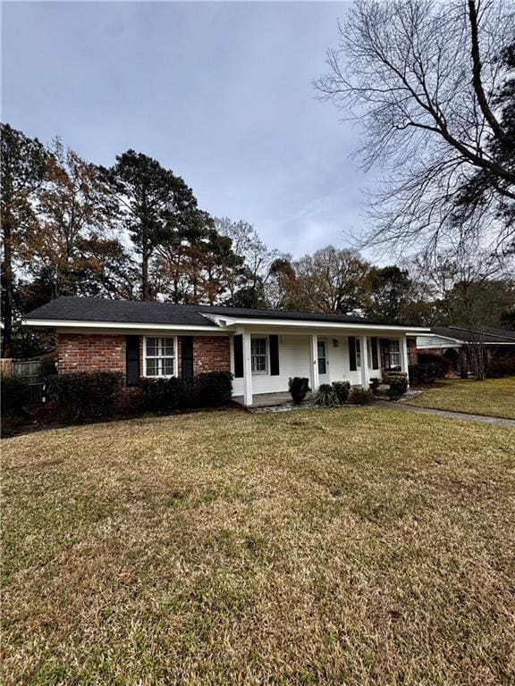 single story home featuring covered porch and a front lawn