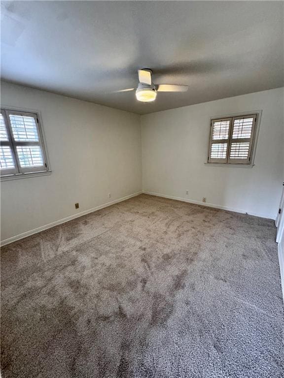 carpeted empty room featuring ceiling fan and a healthy amount of sunlight