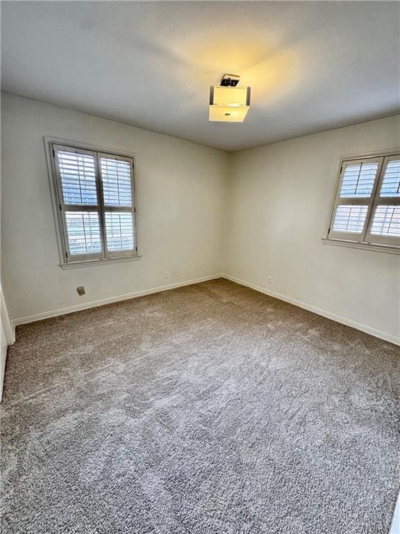 empty room with carpet floors and a wealth of natural light