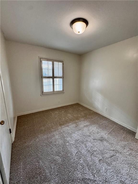 unfurnished room featuring dark carpet