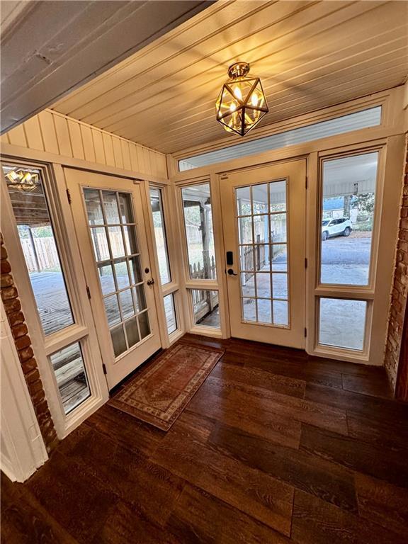 entryway with dark hardwood / wood-style flooring and wood ceiling