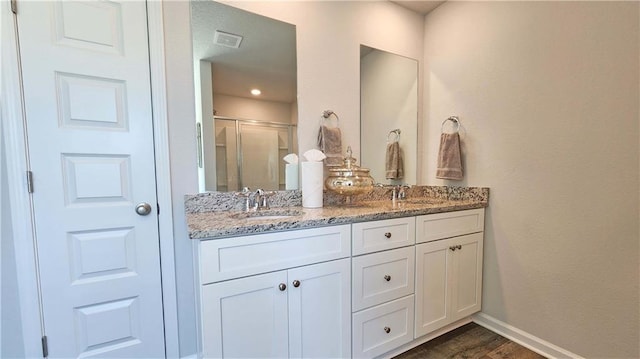 bathroom with vanity, hardwood / wood-style floors, and a shower with shower door