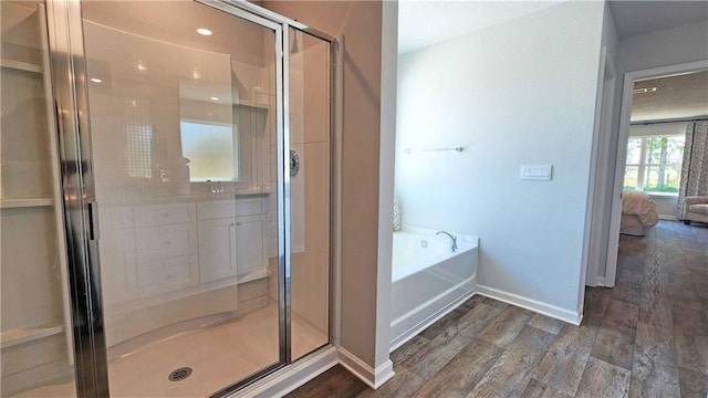 bathroom with hardwood / wood-style floors and shower with separate bathtub