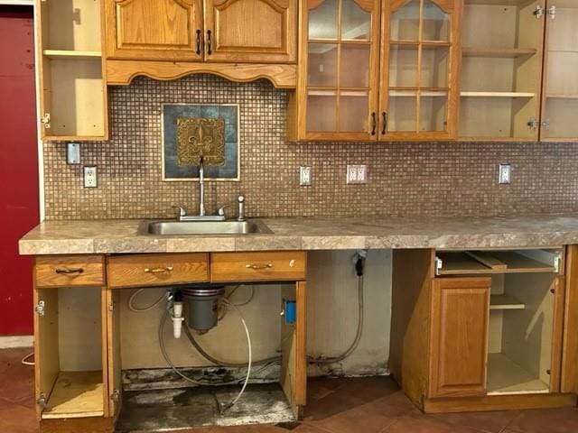 kitchen featuring sink, decorative backsplash, and dark tile patterned flooring