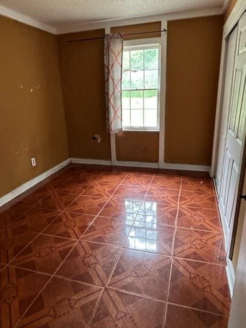 unfurnished room with a textured ceiling