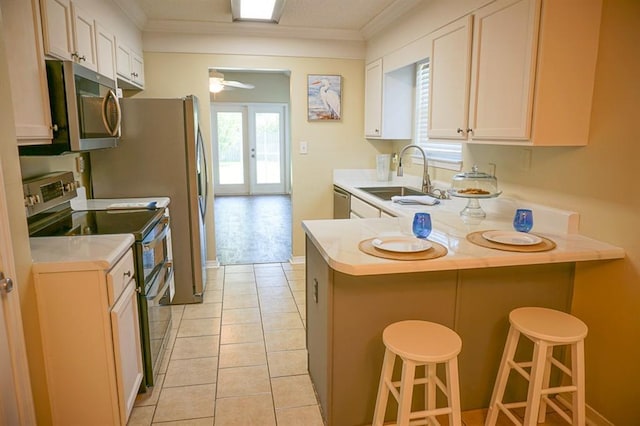 8470 Desert Oak Ct, Mobile, AL 36695 - kitchen featuring stainless steel appliances, a sink, light countertops, a peninsula, and ornamental molding