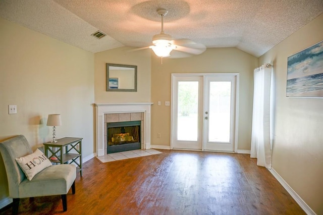 8470 Desert Oak Ct, Mobile, AL 36695 - living room with lofted ceiling, wood finished floors, a ceiling fan, a textured ceiling, and a tile fireplace
