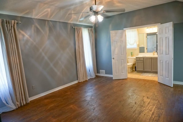 8470 Desert Oak Ct, Mobile, AL 36695 - unfurnished bedroom featuring wood finished floors, baseboards, ensuite bathroom, and multiple windows