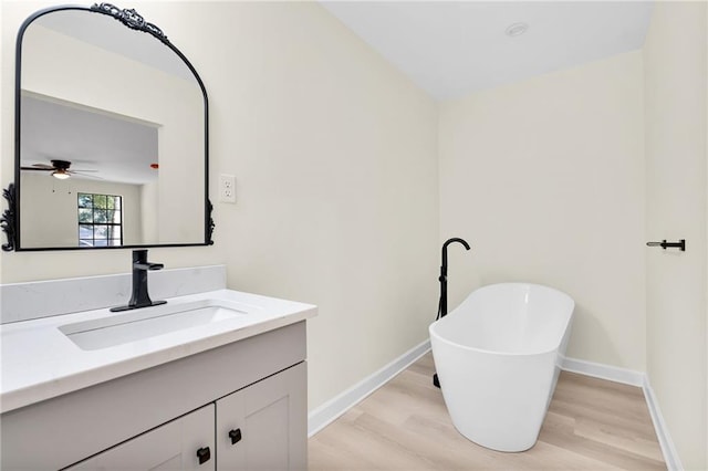 bathroom with vanity, a bath, and hardwood / wood-style floors