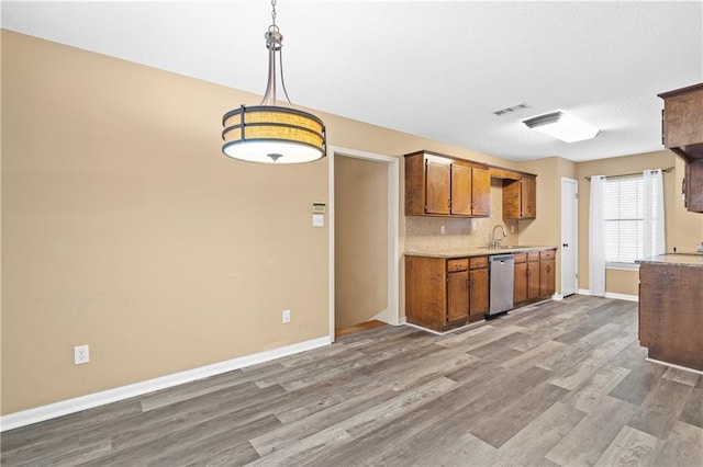 kitchen featuring visible vents, light countertops, dishwasher, and wood finished floors